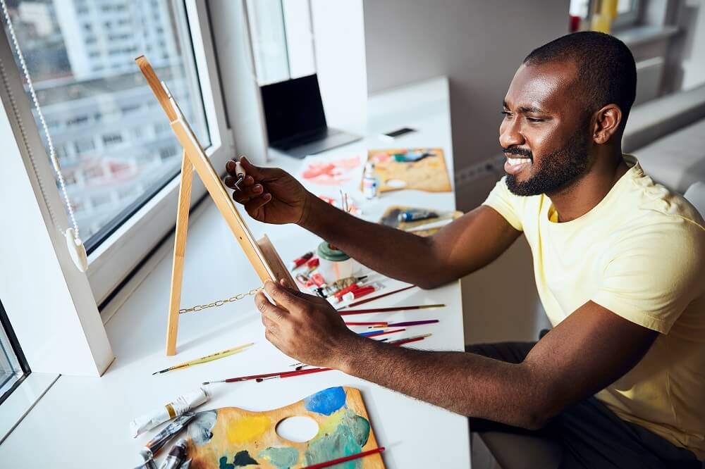 Masculino artístico aplicando tinta à tela